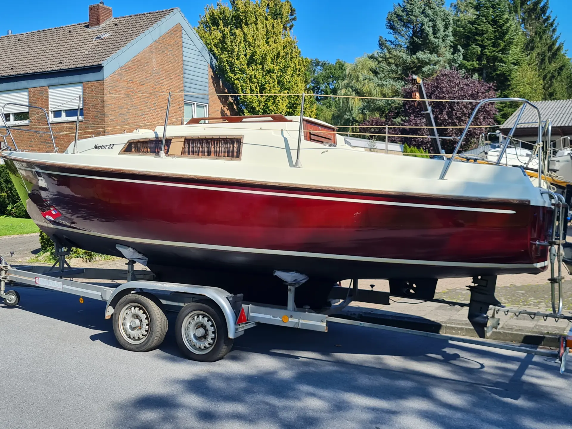 Neptun 22 mit rotem Rumpf und weißem Deck auf Trailer