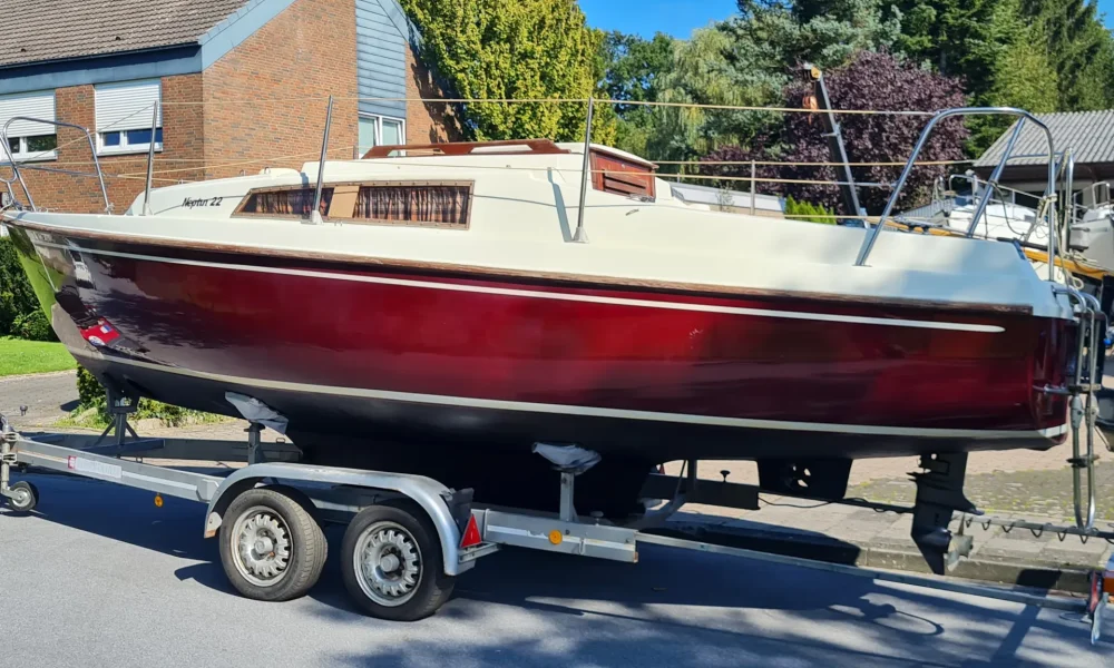 Neptun 22 mit rotem Rumpf und weißem Deck auf Trailer