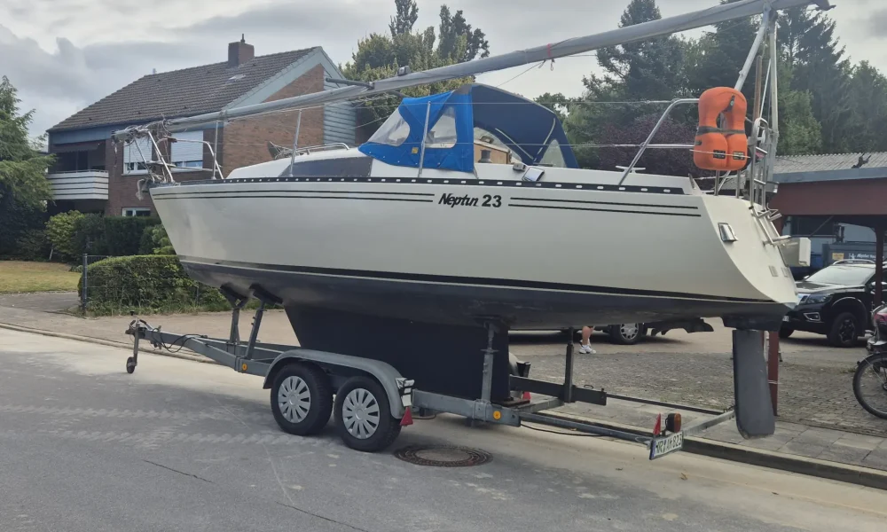 Neptun 23 Segelboot kaufen – Steuerbordansicht mit Sprayhood auf Trailer